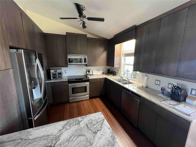kitchen with appliances with stainless steel finishes, a sink, dark wood-style floors, a ceiling fan, and lofted ceiling