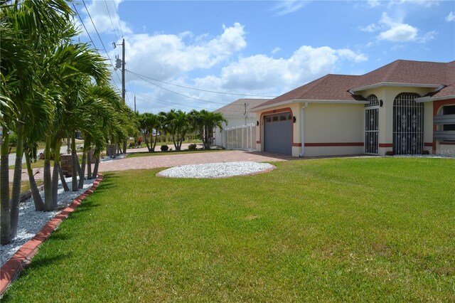 1118 NW 17th St, Cape Coral, FL 33993 - view of yard featuring a garage and concrete driveway