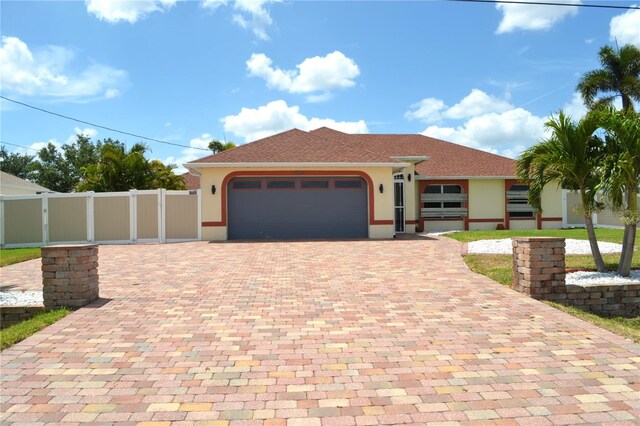 1118 NW 17th St, Cape Coral, FL 33993 - view of front of house featuring a garage, decorative driveway, stucco siding, and fence