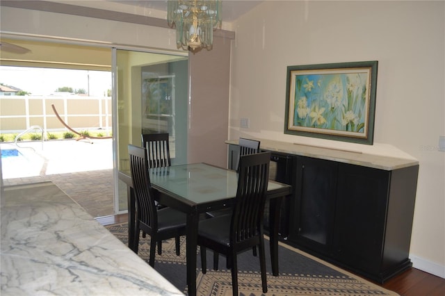 1118 NW 17th St, Cape Coral, FL 33993 - dining space with an inviting chandelier, baseboards, and dark wood-type flooring