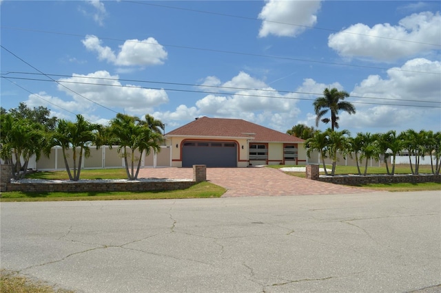 1118 NW 17th St, Cape Coral, FL 33993 - ranch-style home with an attached garage, decorative driveway, fence, and stucco siding