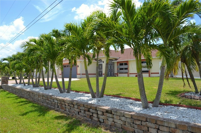 1118 NW 17th St, Cape Coral, FL 33993 - view of front of home with stucco siding, a garage, and a front lawn