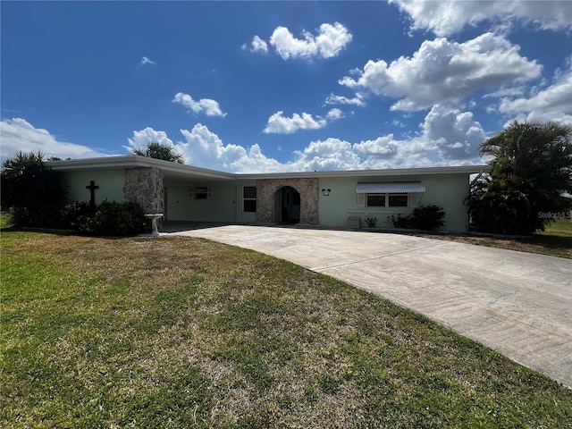 single story home with stone siding, a front yard, stucco siding, concrete driveway, and a carport
