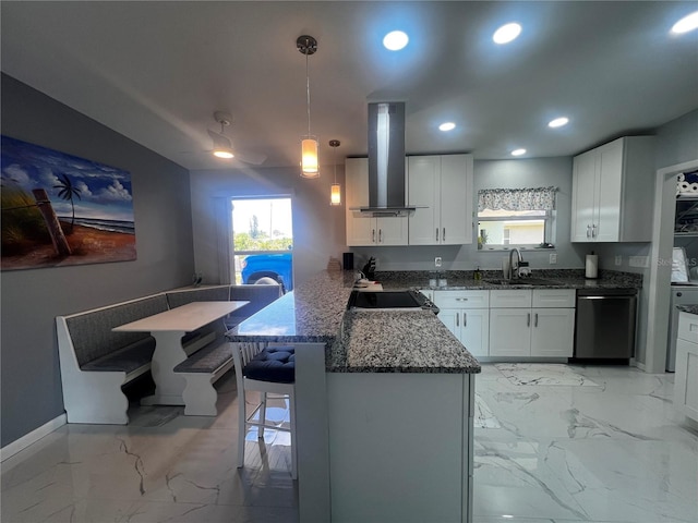 kitchen with island range hood, dishwasher, a sink, dark stone countertops, and a peninsula