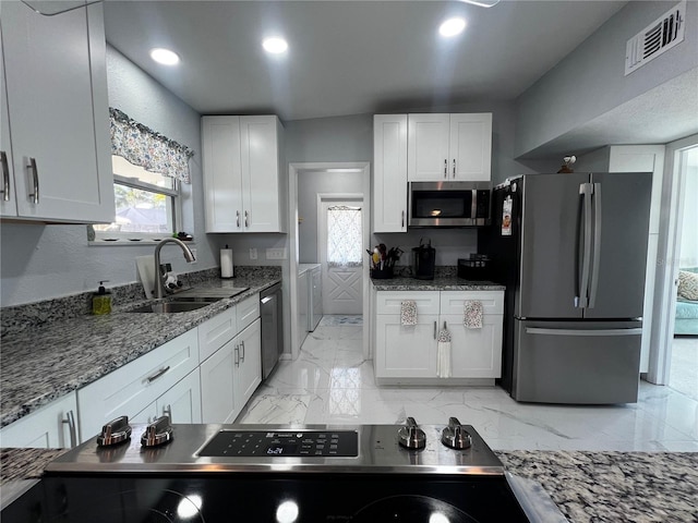 kitchen with visible vents, marble finish floor, white cabinetry, a sink, and stainless steel appliances