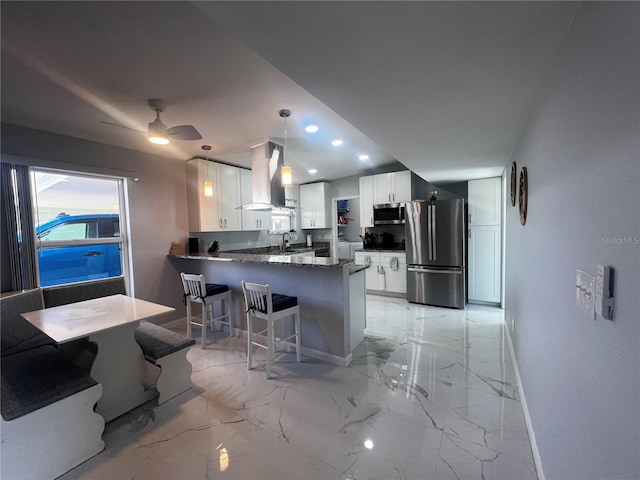 kitchen with baseboards, a peninsula, marble finish floor, stainless steel appliances, and extractor fan