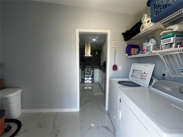 clothes washing area with washing machine and clothes dryer, laundry area, baseboards, and marble finish floor
