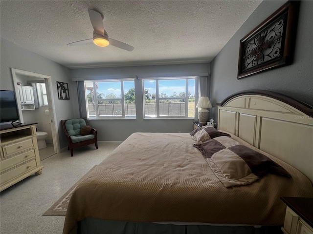 bedroom with carpet flooring, a textured ceiling, multiple windows, and ensuite bathroom