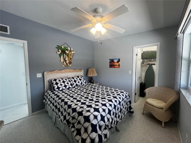 bedroom with visible vents, a closet, baseboards, a walk in closet, and a ceiling fan