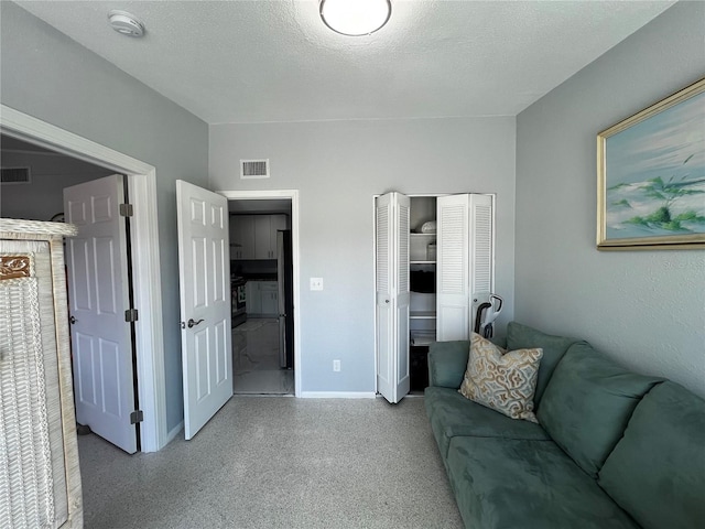 living area featuring baseboards, visible vents, and speckled floor