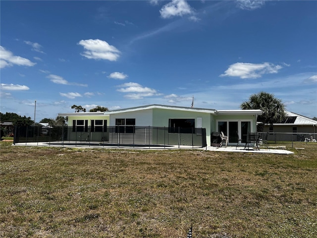 back of property with a lawn, fence, and a patio area