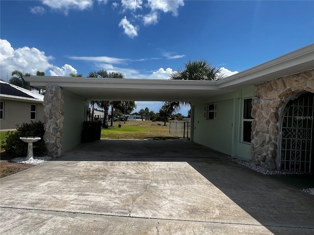 view of vehicle parking with concrete driveway and an attached carport