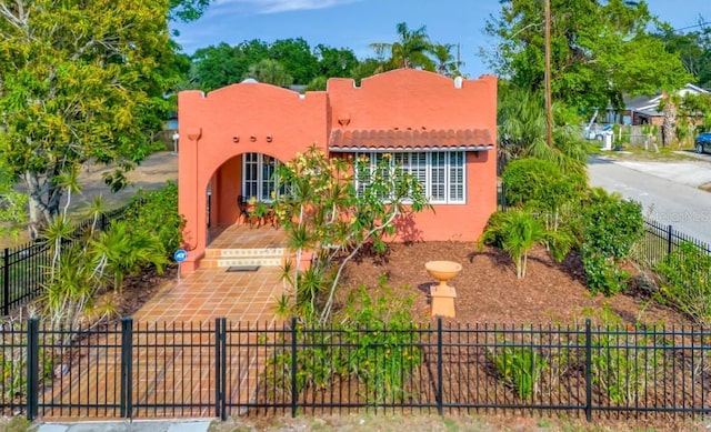 2002 Central Ave, Sarasota, FL 34234 - pueblo-style home featuring stucco siding, a fenced front yard, and a tiled roof
