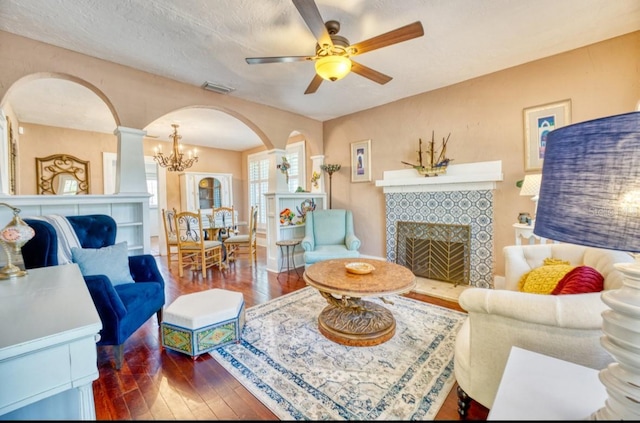 2002 Central Ave, Sarasota, FL 34234 - living area with arched walkways, hardwood / wood-style floors, a tiled fireplace, ceiling fan, and a chandelier