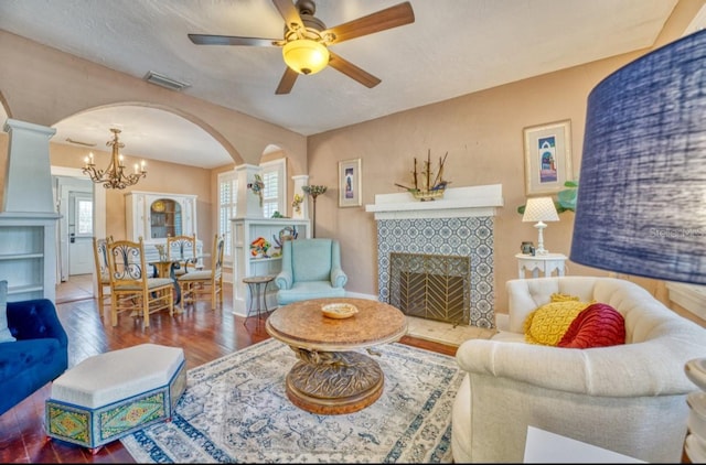 2002 Central Ave, Sarasota, FL 34234 - living room with arched walkways, hardwood / wood-style floors, a ceiling fan, a fireplace, and a chandelier