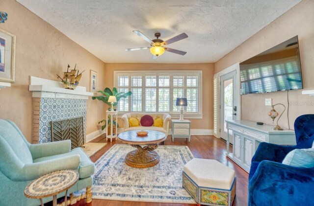 2002 Central Ave, Sarasota, FL 34234 - living room featuring a ceiling fan, wood finished floors, a textured ceiling, and a fireplace