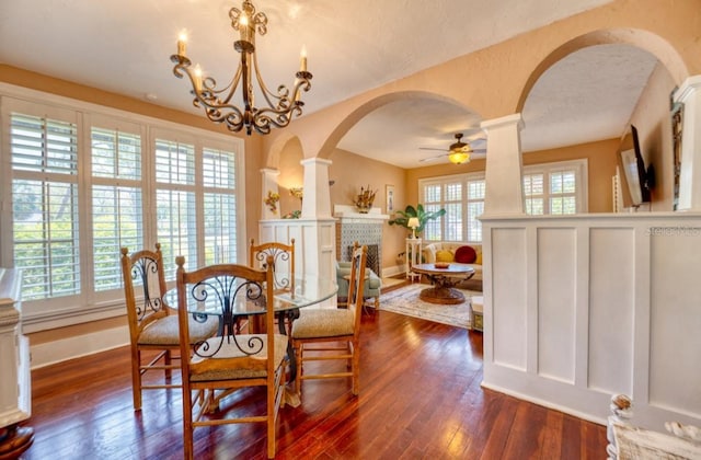 2002 Central Ave, Sarasota, FL 34234 - dining area with arched walkways, dark wood-type flooring, a ceiling fan, and decorative columns