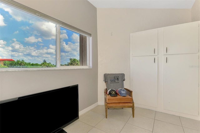 living area with light tile patterned floors and baseboards
