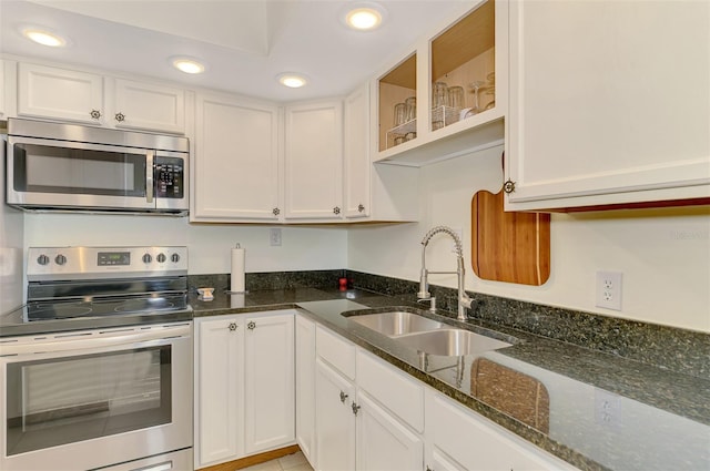 kitchen with appliances with stainless steel finishes, a sink, white cabinets, and recessed lighting