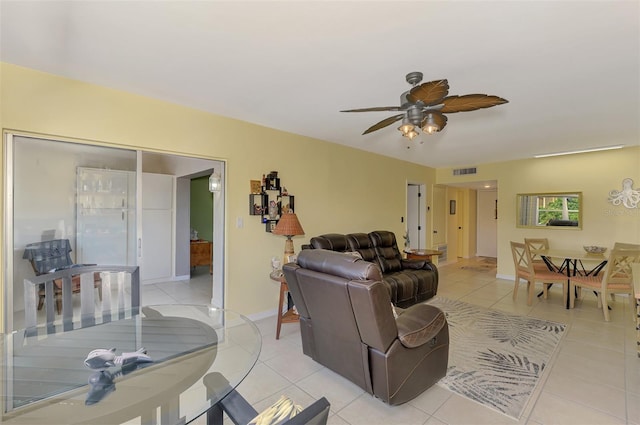 living room with light tile patterned floors, ceiling fan, and baseboards