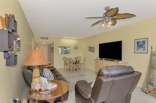 living area with light tile patterned flooring, ceiling fan, and baseboards