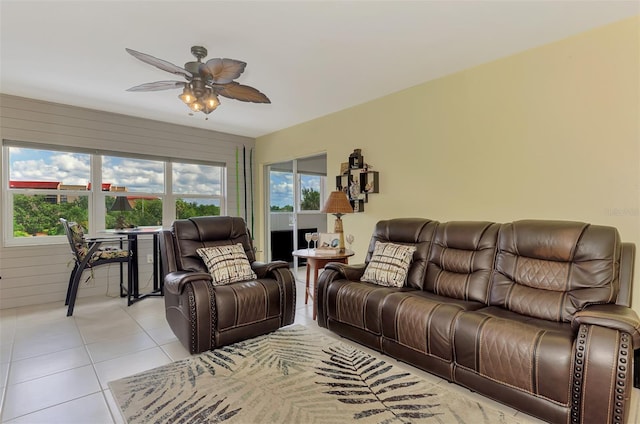 living area with light tile patterned floors and ceiling fan