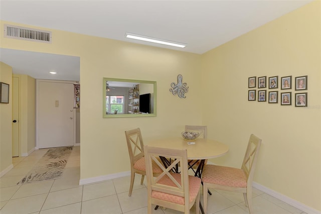 tiled dining room featuring baseboards