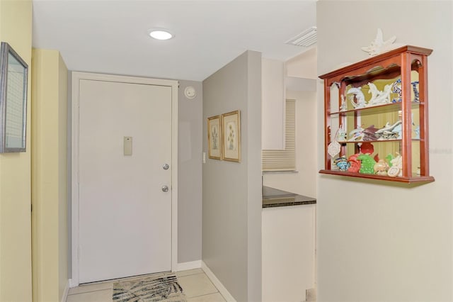 foyer with light tile patterned floors and baseboards
