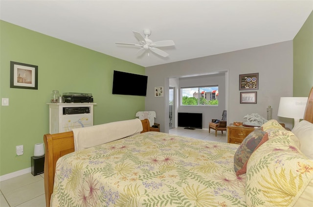 bedroom featuring light tile patterned floors, baseboards, and ceiling fan