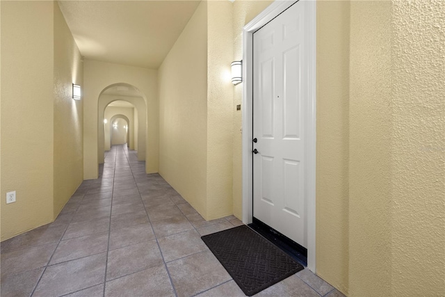 95 Vivante Blvd # 9524, Punta Gorda, FL 33950 - hallway featuring arched walkways, a textured wall, and light tile patterned floors