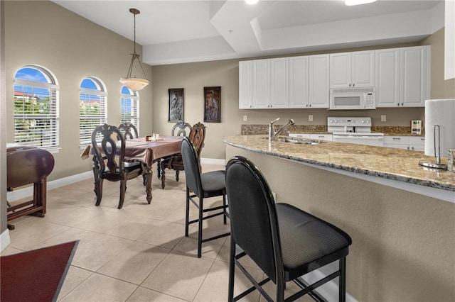 95 Vivante Blvd # 9524, Punta Gorda, FL 33950 - kitchen with pendant lighting, a sink, baseboards, white cabinets, and white appliances