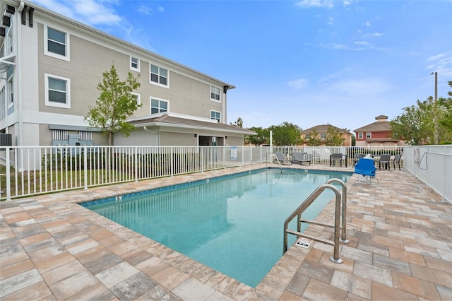 community pool with fence and a patio