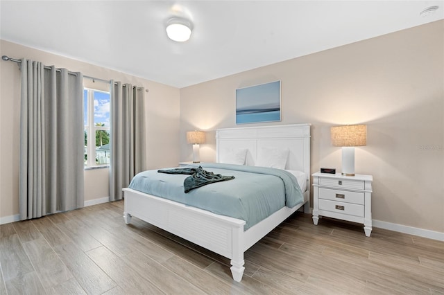 bedroom with baseboards and light wood-type flooring