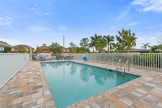 community pool featuring fence and a patio
