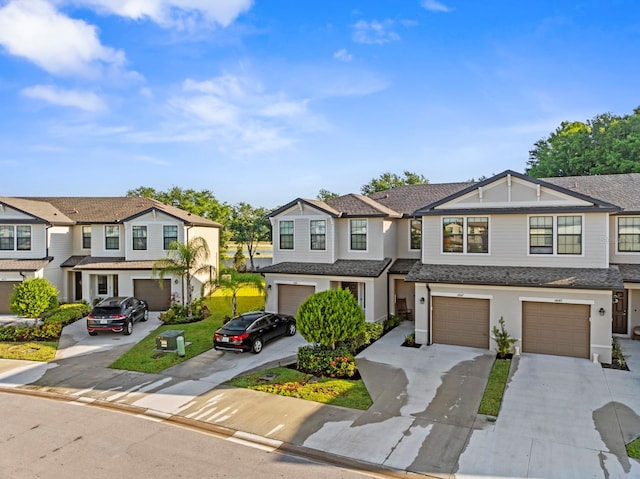 view of property featuring a residential view, roof with shingles, an attached garage, stucco siding, and driveway