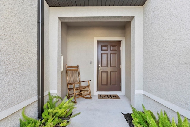 property entrance with stucco siding