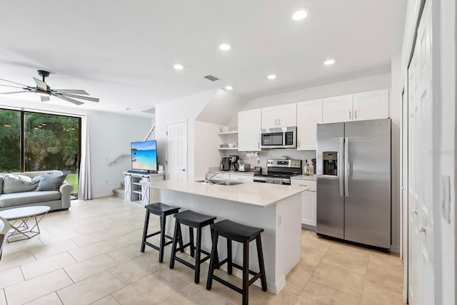 kitchen with a breakfast bar area, visible vents, appliances with stainless steel finishes, a sink, and white cabinetry