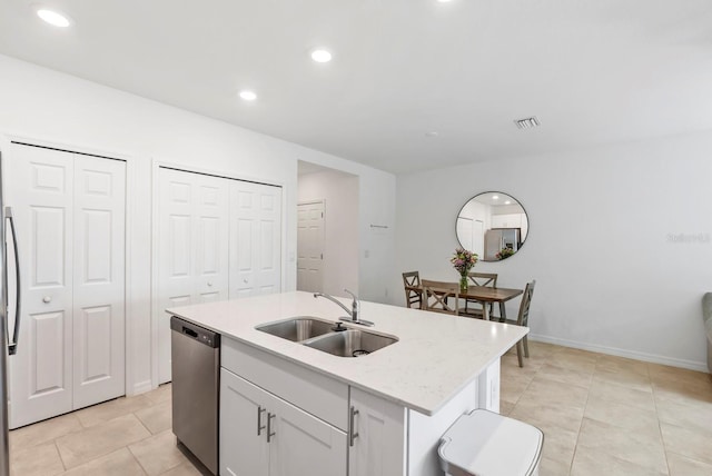 kitchen with a sink, a kitchen island with sink, stainless steel appliances, white cabinetry, and visible vents