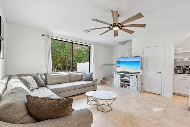 living room featuring light tile patterned floors, stairway, a ceiling fan, and visible vents
