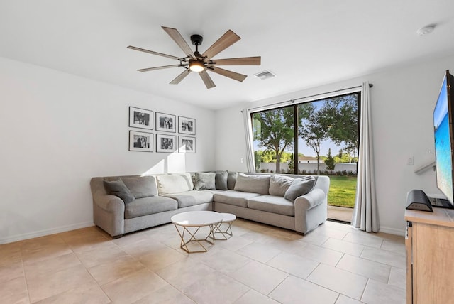 living area with visible vents, baseboards, ceiling fan, and light tile patterned floors
