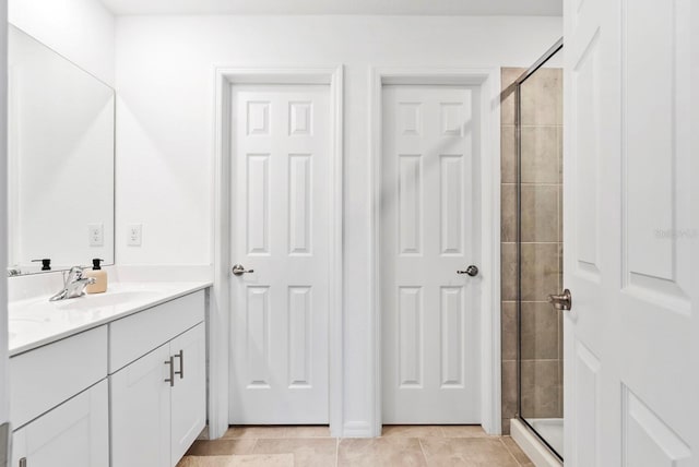 full bathroom with vanity, tile patterned flooring, and tiled shower
