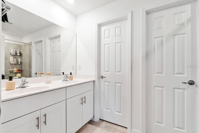 full bathroom with a sink, tile patterned floors, a tile shower, and double vanity