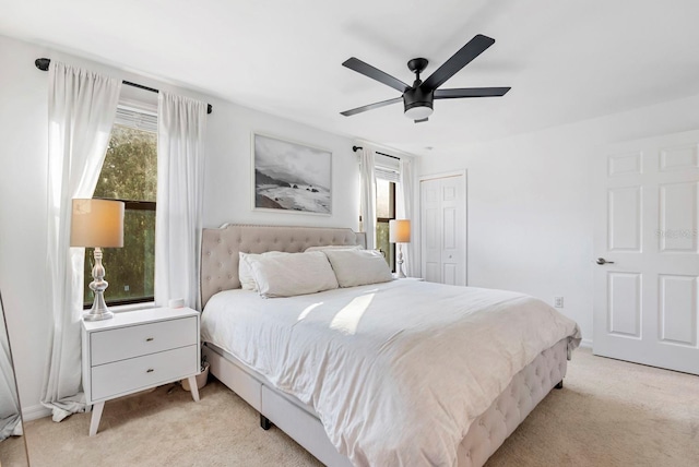 bedroom featuring a closet, a ceiling fan, and light carpet