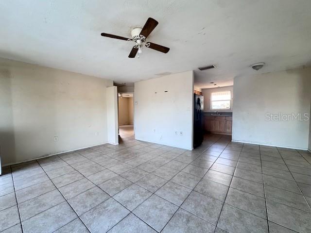 spare room featuring light tile patterned floors, ceiling fan, and visible vents