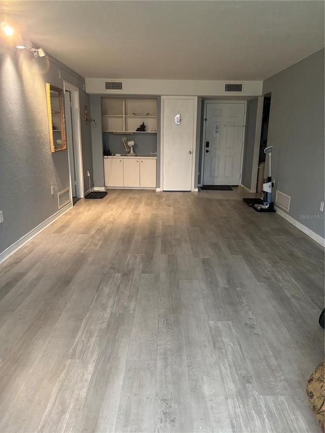618 Bird Bay Dr S Unit 109, Venice, FL 34285 - unfurnished living room with wood finished floors and baseboards