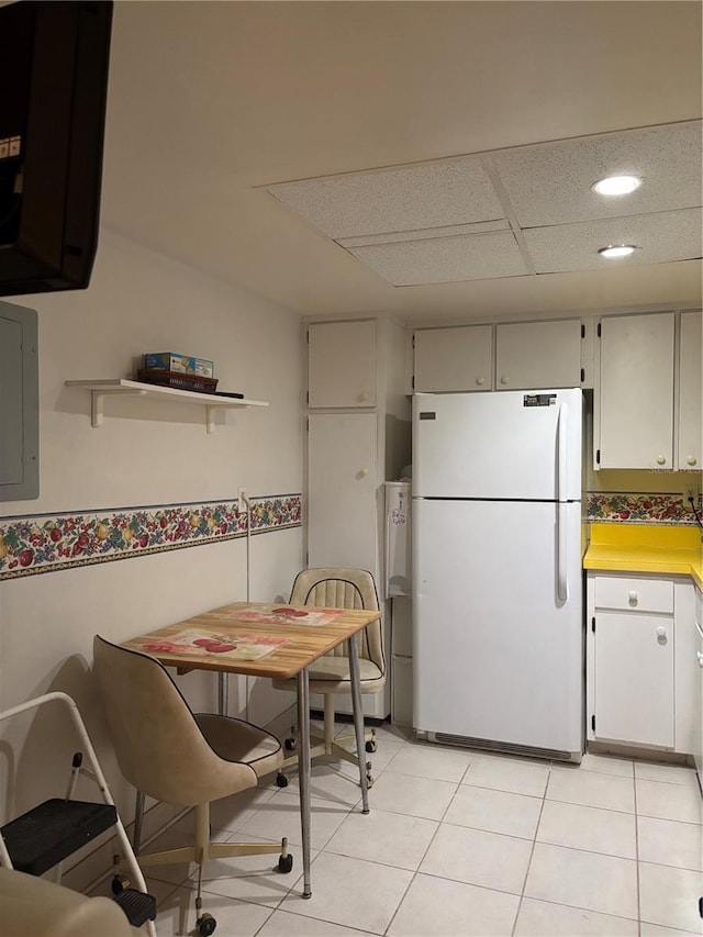 618 Bird Bay Dr S Unit 109, Venice, FL 34285 - kitchen featuring freestanding refrigerator, electric panel, light countertops, light tile patterned flooring, and recessed lighting