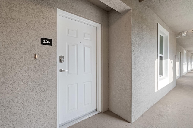 view of exterior entry featuring stucco siding