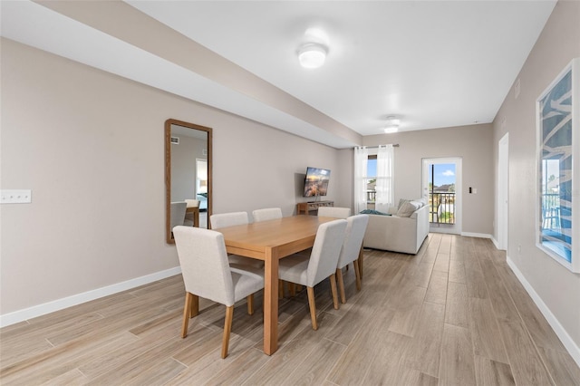 dining room featuring light wood-type flooring and baseboards