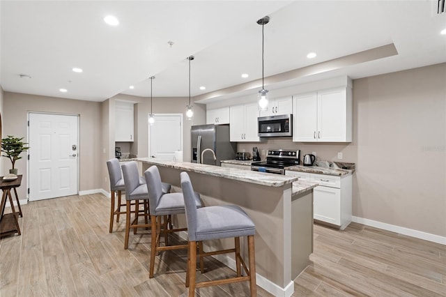 kitchen with appliances with stainless steel finishes, baseboards, light wood finished floors, white cabinets, and recessed lighting