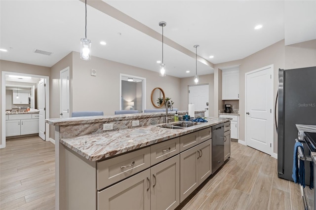 kitchen with a sink, stainless steel appliances, light wood-type flooring, decorative light fixtures, and recessed lighting